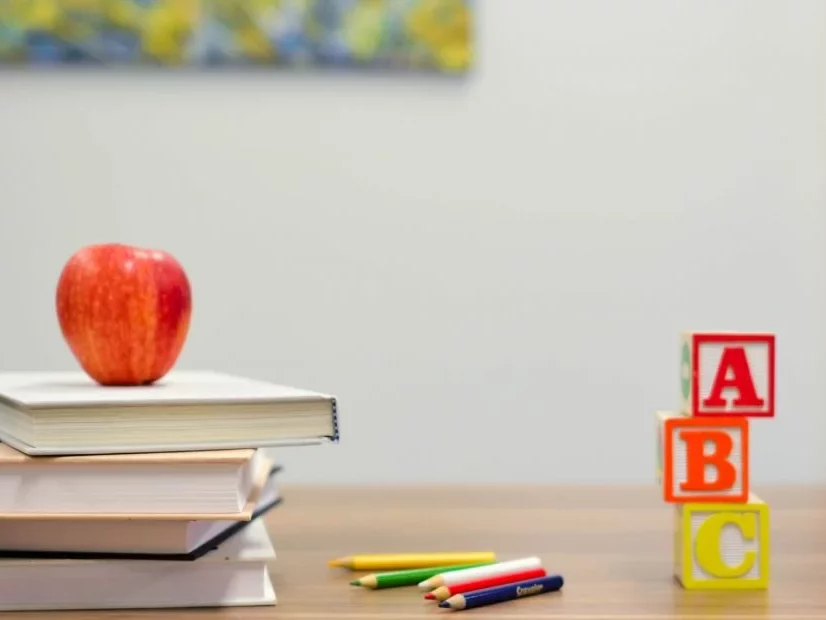 Coloured Pencils and Books with an Apple