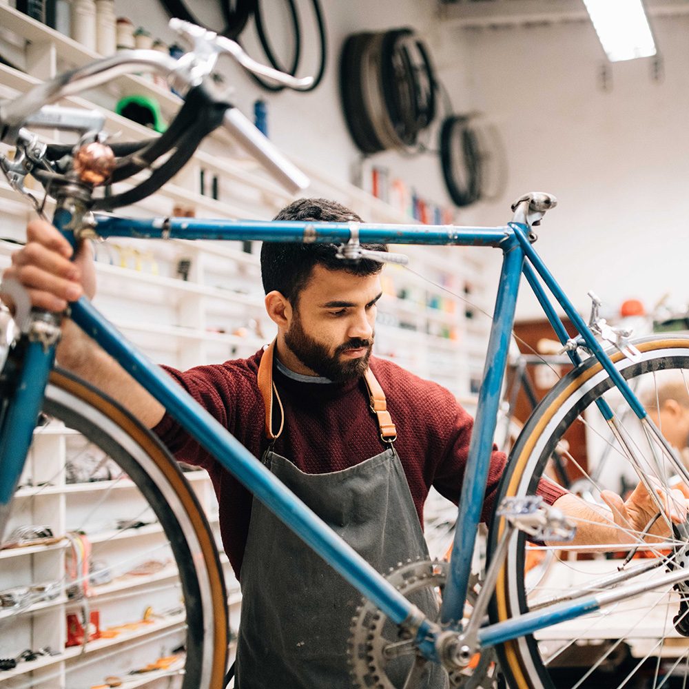 Employee Fixing a Bike in a Bike Store