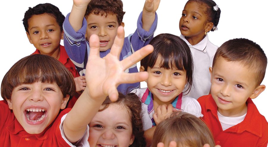 A group of school children celebrating with their hands in the air.