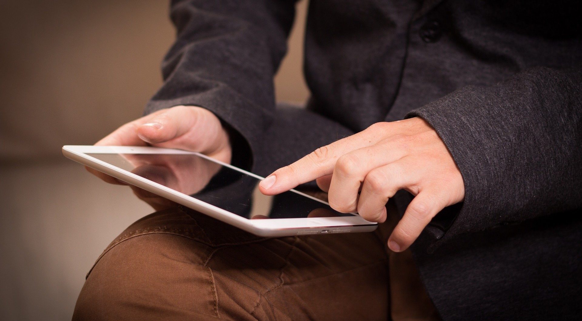 Person using a tablet while sat down.