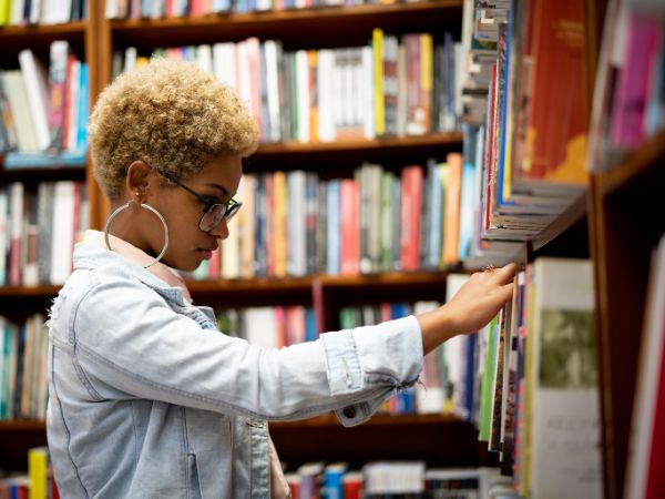 A woman selecting books in a library