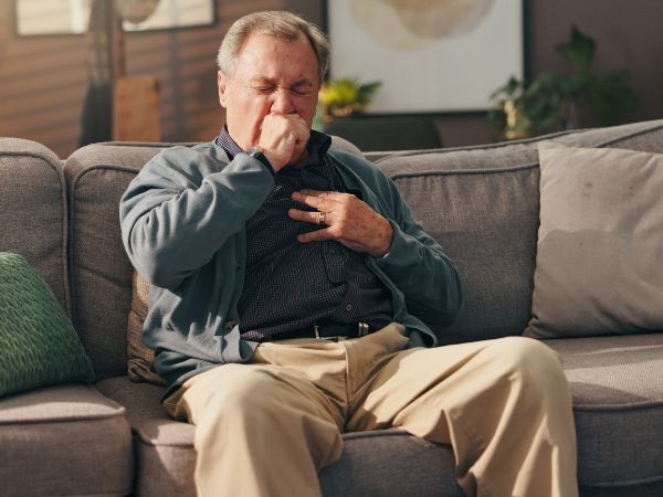 Man on sofa coughing