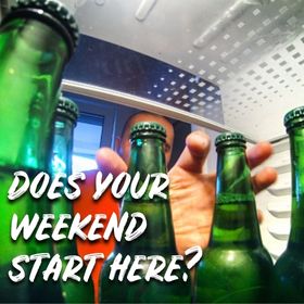 Hand reaching into the fridge for beer bottles