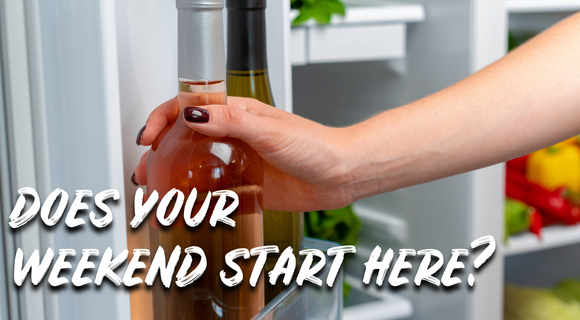 Hand reaching into the fridge for a bottle of wine