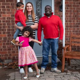 Happy smiling family outside their home