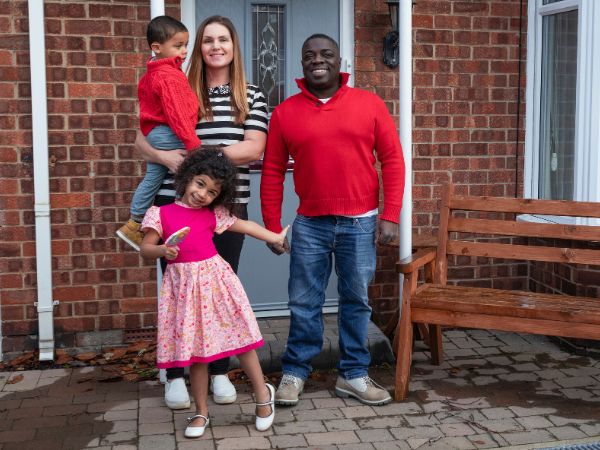 Happy smiling family outside their home