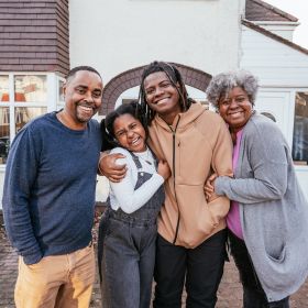Happy family smiling outside their home