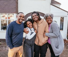Happy family smiling outside their home