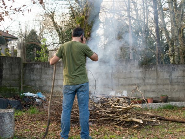 man burning garden refuse in garden