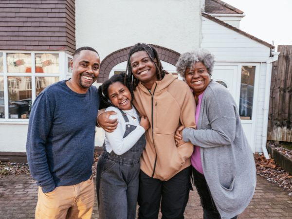 Happy family smiling outside their home