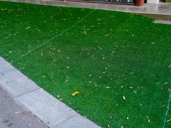 Artificial grass lawn with fallen leaves