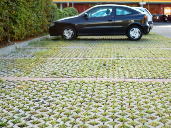 Car parked on semi permeable surface that allows grass to grow through